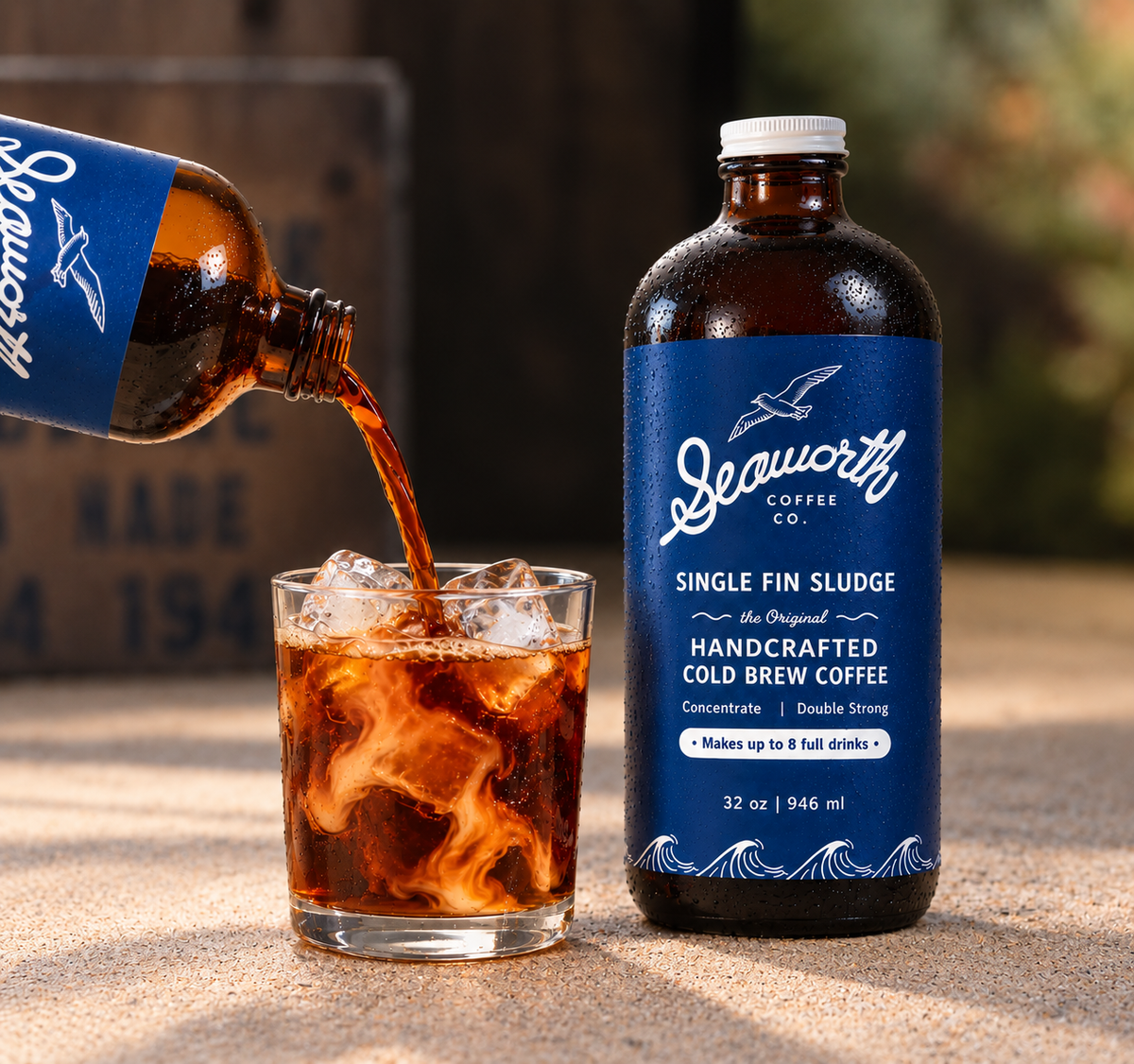 Seaworth Single Fin Sludge cold brew concentrate poured over ice beside a 32 oz bottle